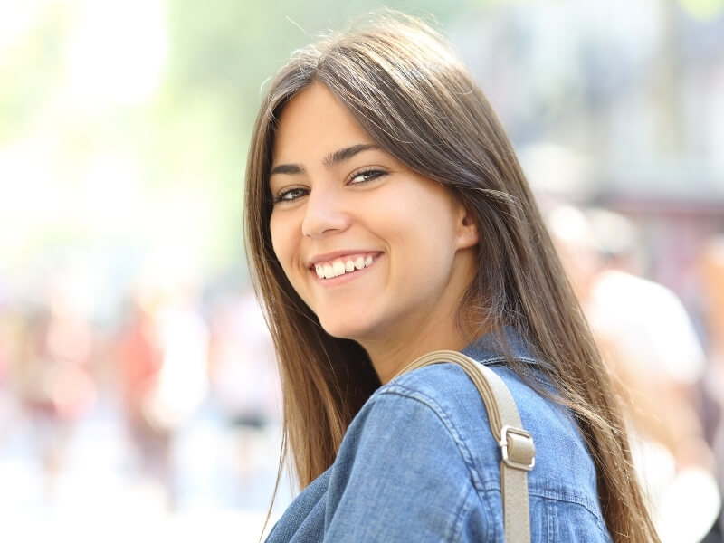 A smiling woman stands confidently-mobile