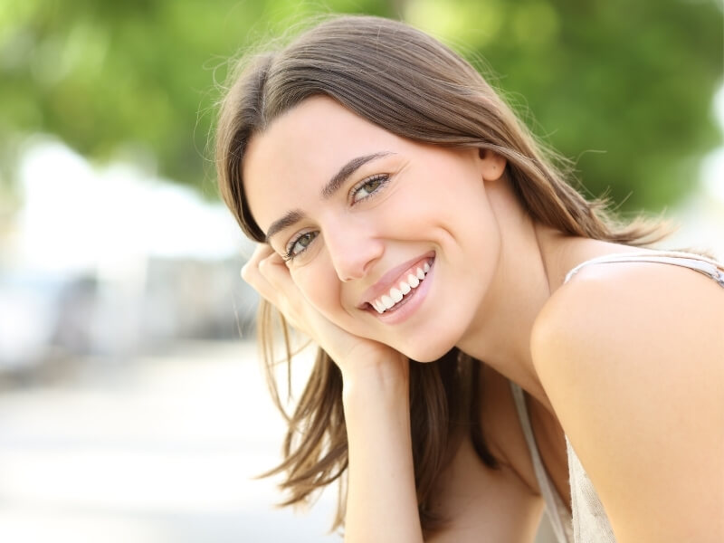 A woman with a bright smile sits comfortably