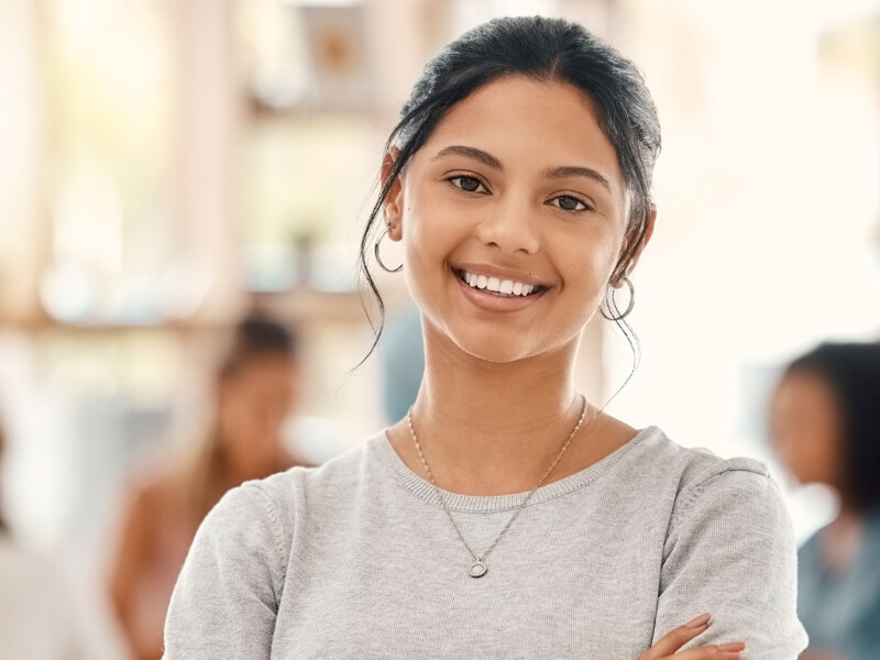 A woman smiles warmly while standing in front