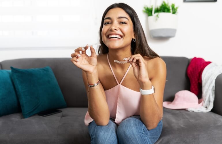 Happy woman showing dental aligner