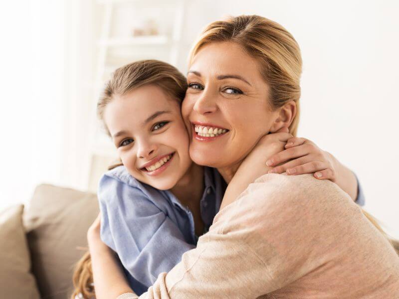 Mother and daughter hugging happily