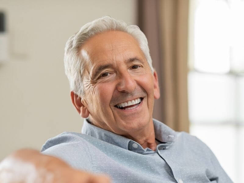 A woman with a bright smile sits comfortably