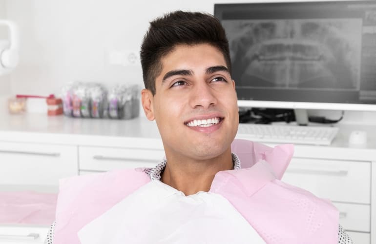 Smiling man at dental clinic.<br />
