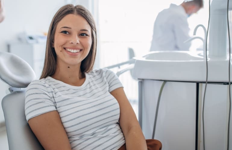 Women smiling while seated on dental chair